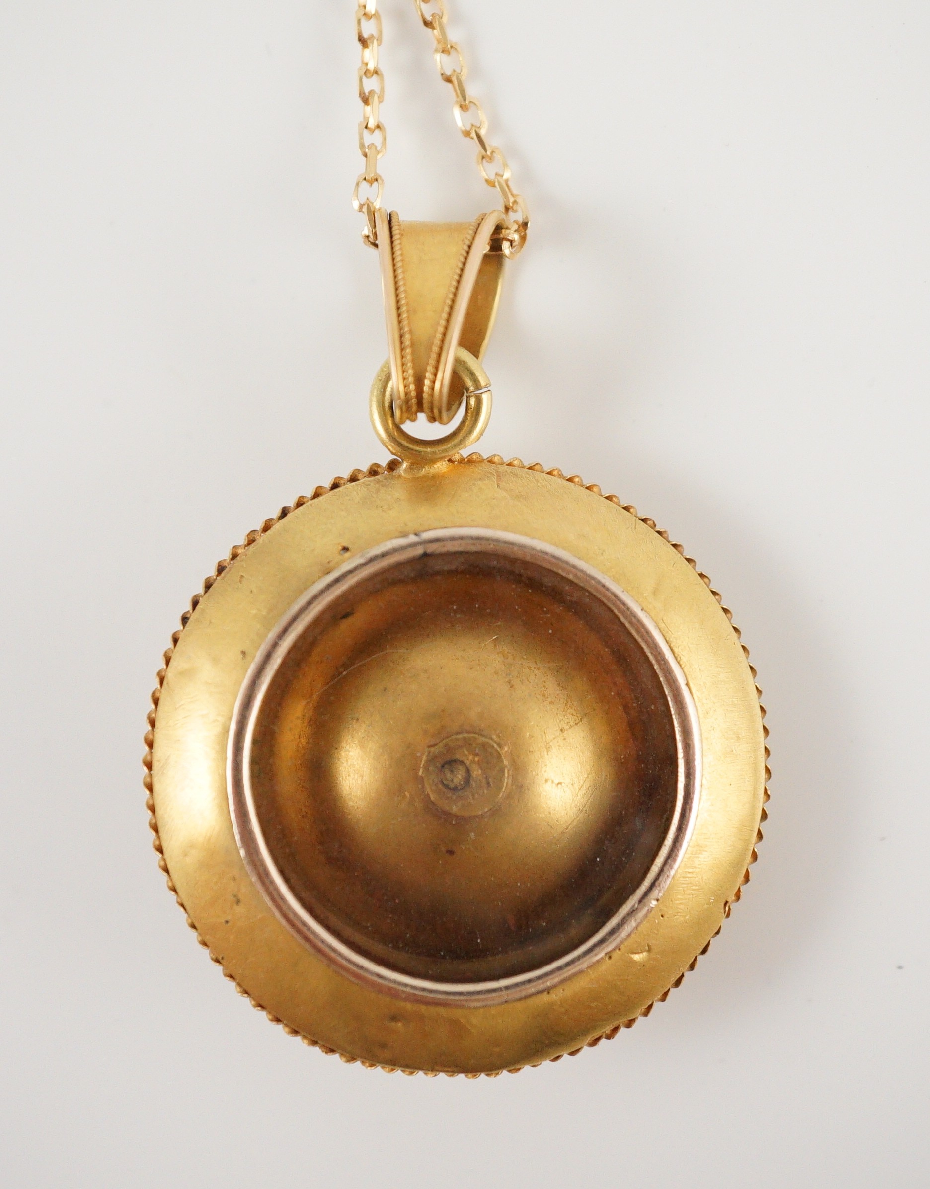 A Victorian gold circular pendant, with flower head centre and glazed back, on a later 9ct gold chain